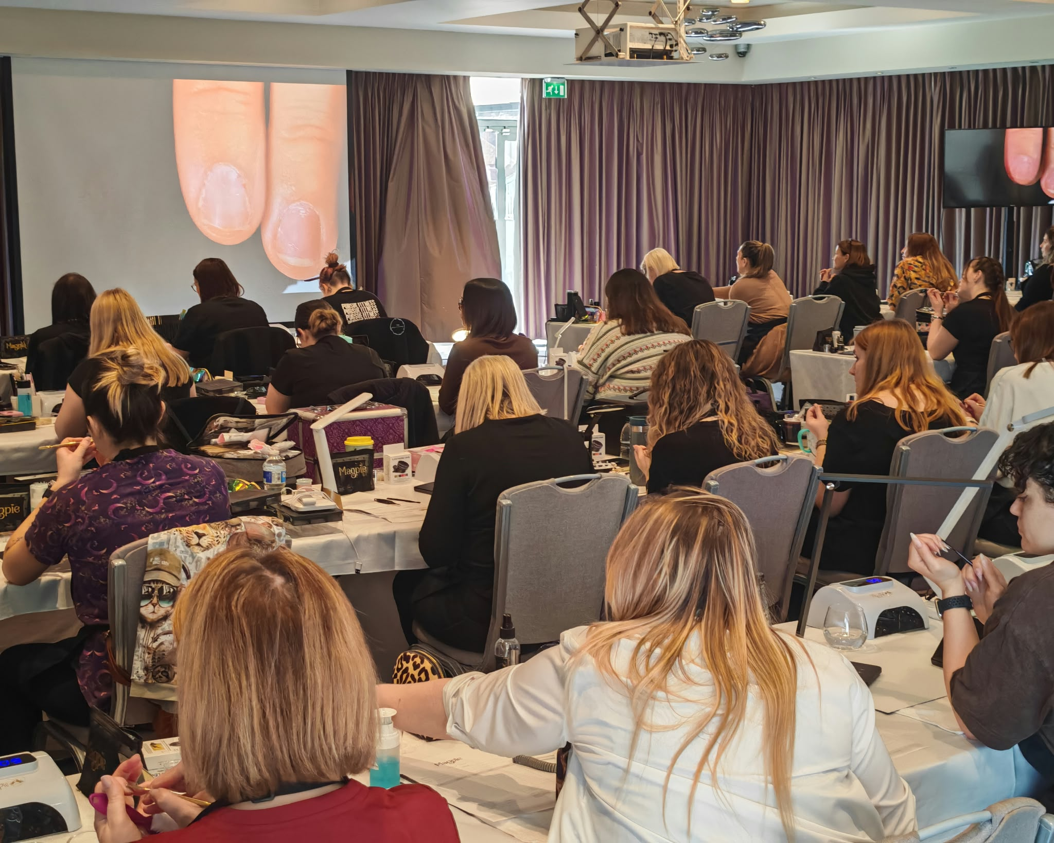 Nail technicians learning together during a Magpie Skill School training session